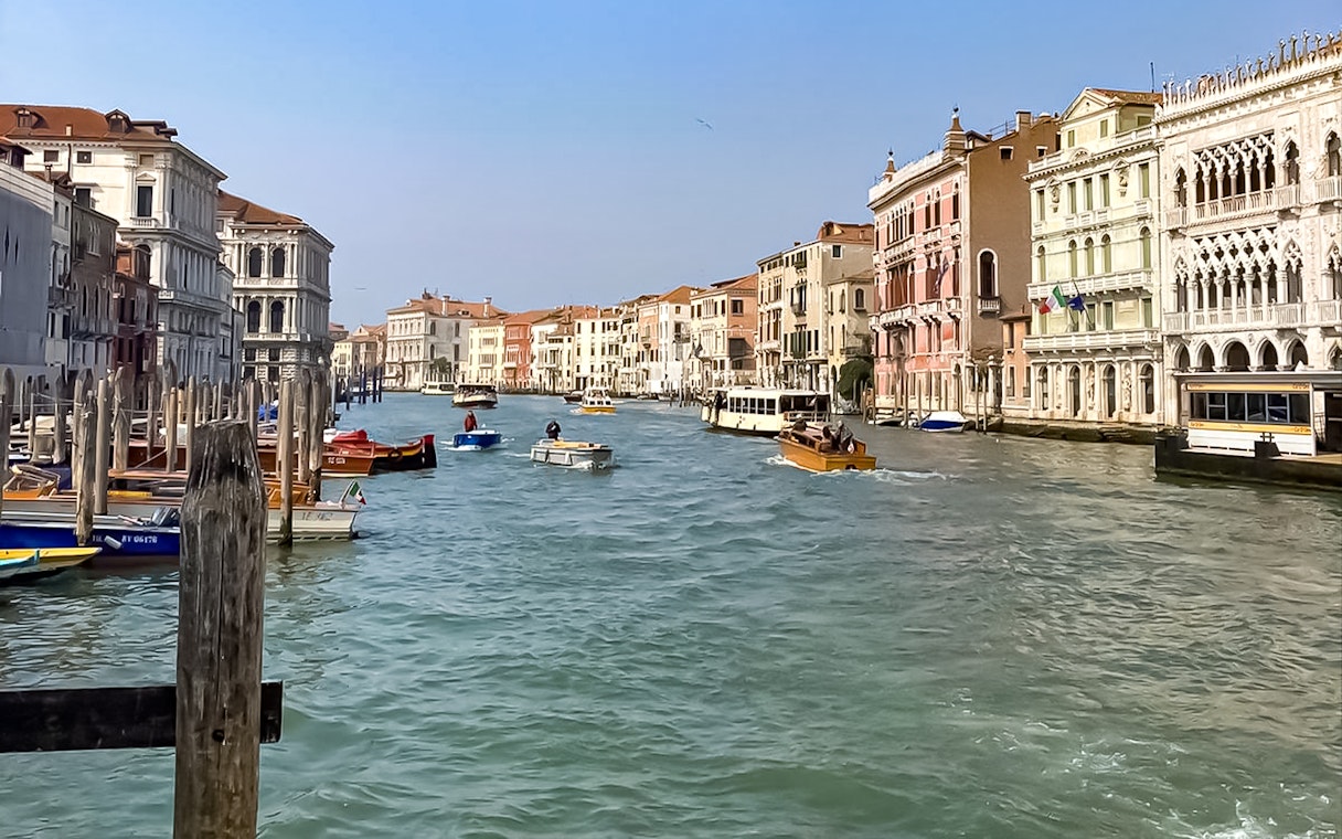 Sightseeing boats on Venice's Grand Canal with historic buildings lining the waterway.