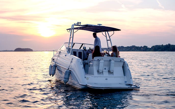 Speedboat tour of southern islands at sunset with people enjoying drinks.