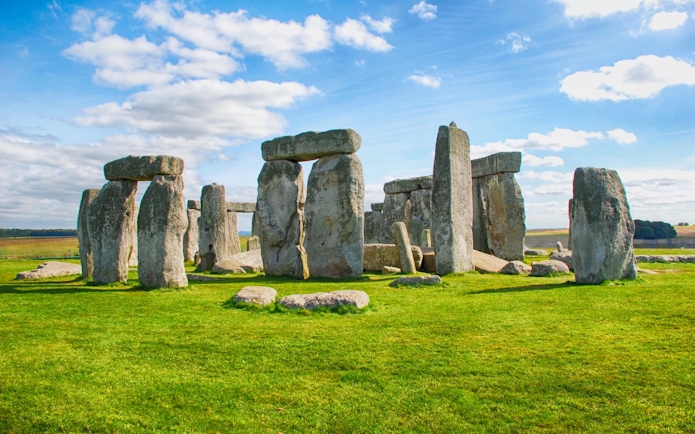 Stonehenge stone circle under a blue sky in Wiltshire, England.