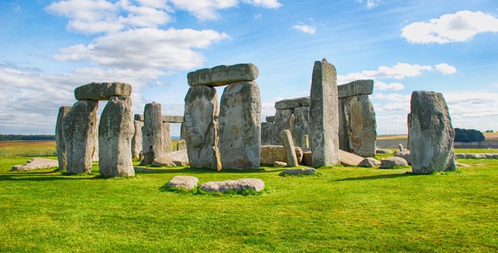 Stonehenge stone circle under a blue sky in Wiltshire, England.