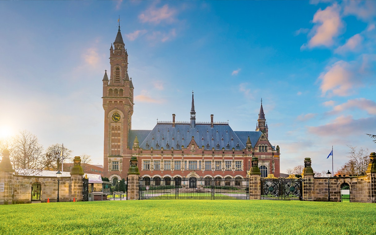Peace Palace in Hague, home to the International Court of Justice, with clock tower and gardens.