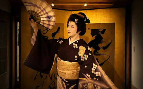 Geisha performing with a fan during a show in Asakusa, Tokyo.