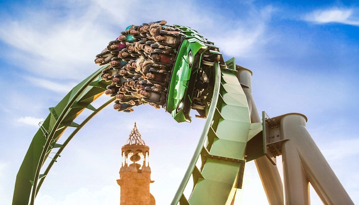 Guests on a rollercoaster with Islands of Adventure tower in background, Universal Studios Orlando.