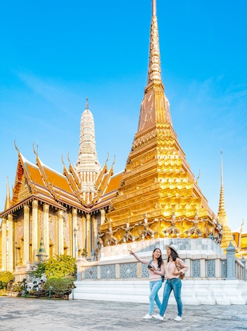 Tourists exploring Wat Pra Kaew temple in Bangkok.