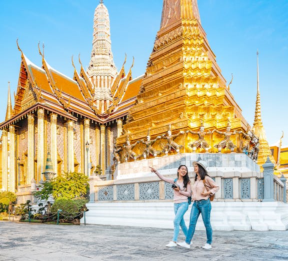 Tourists exploring Wat Pra Kaew temple in Bangkok.