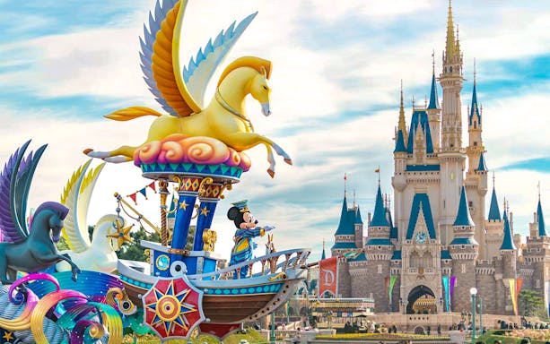 Mickey Mouse on a colorful float at Tokyo DisneySea with a castle in the background.