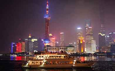 Cruise on Huangpu River with Shanghai skyline, including Oriental Pearl Tower.