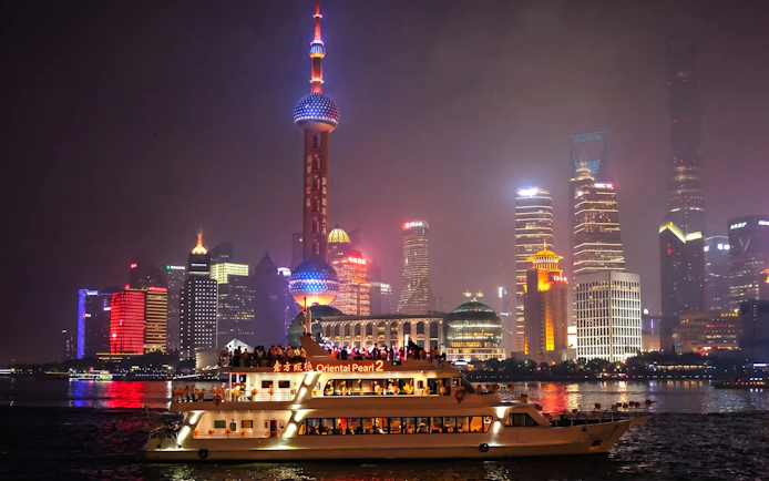 Cruise on Huangpu River with Shanghai skyline, including Oriental Pearl Tower.