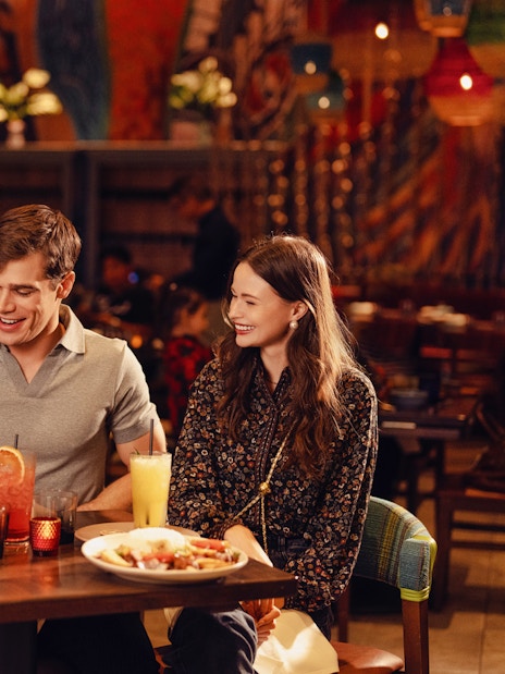 Guests dining at a vibrant restaurant in American Dream, enjoying drinks and meals.