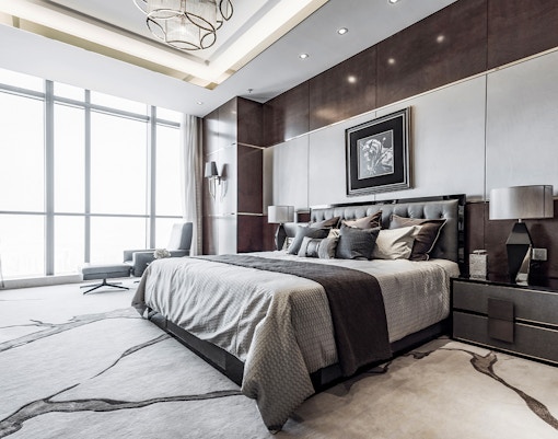 Luxury hotel room with king-size bed, modern decor, and large window view.