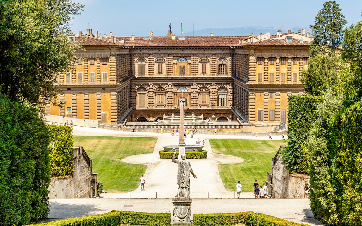 Gardens and exterior view of Pitti Palace in Florence, Italy, with visitors exploring.