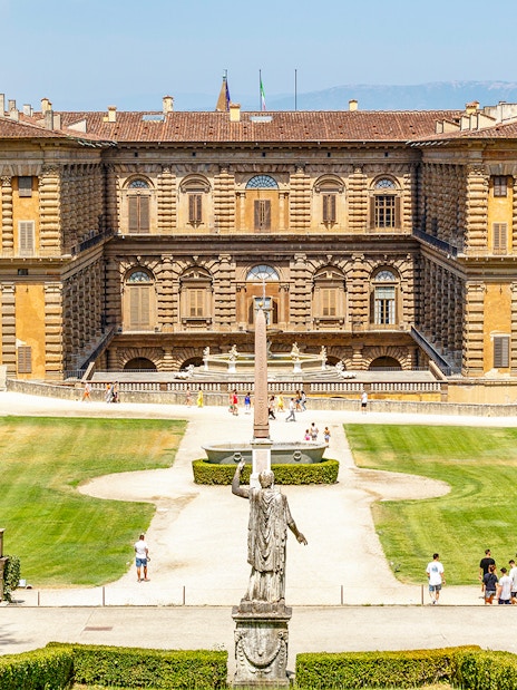 Gardens and exterior view of Pitti Palace in Florence, Italy, with visitors exploring.