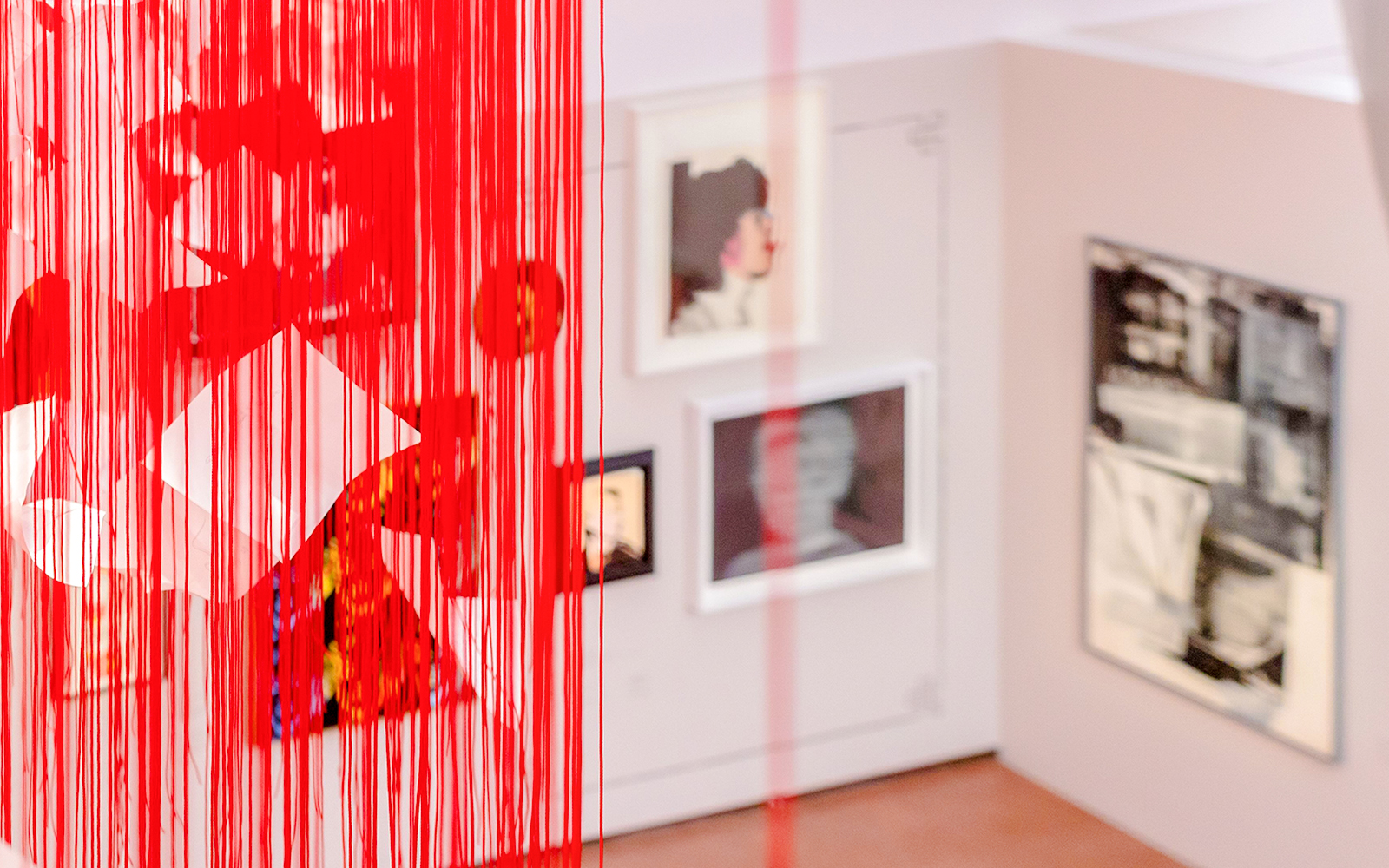 Exhibition view with red string installation and framed artworks at Heidi Horten Collection Vienna.