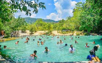 Visitors enjoying the Emerald Pool in Krabi surrounded by lush greenery.