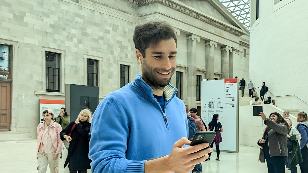 British Museum entrance with visitors using audio guides in London.