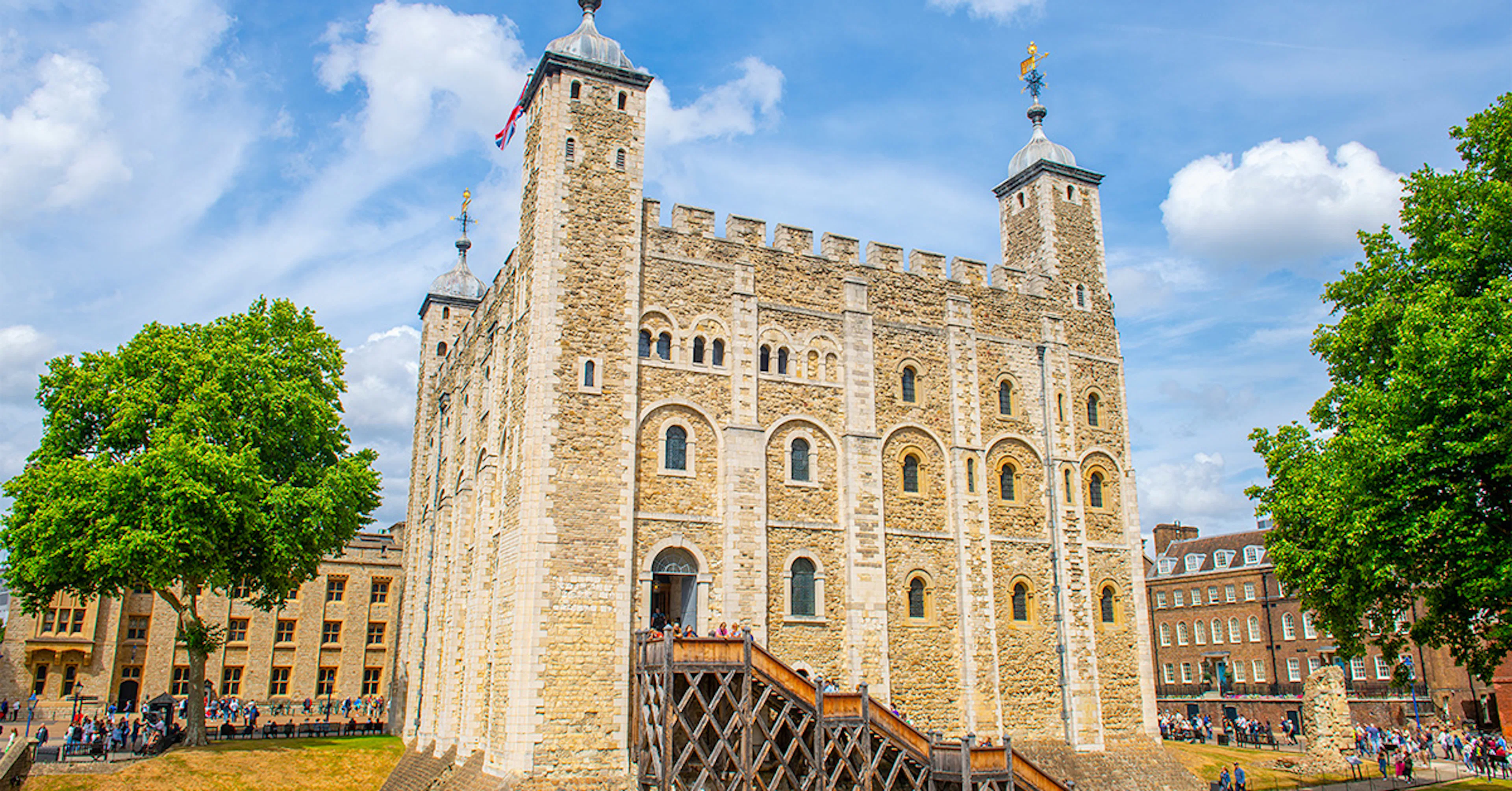 White Tower at the Tower of London with tourists exploring the historic site.