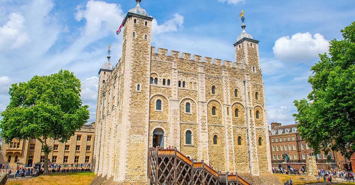 White Tower at the Tower of London with tourists exploring the historic site.