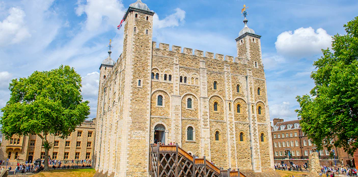 White Tower at the Tower of London with tourists exploring the historic site.