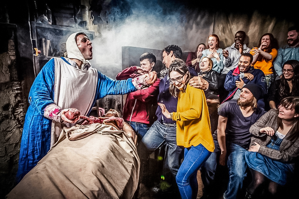 Visitors react to a theatrical performance at The London Dungeon.