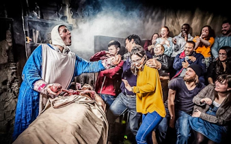 Visitors react to a theatrical performance at The London Dungeon.