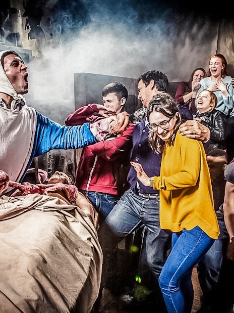 Visitors react to a theatrical performance at The London Dungeon.
