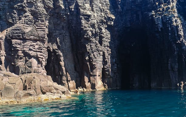 Sant'Antioco Island sightseeing cruise with skipper, featuring coastal views and clear blue waters.