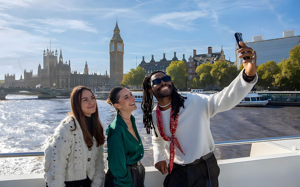 Group enjoying a selfie on a London sightseeing cruise with Big Ben in the background.