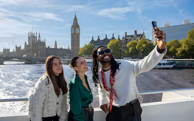 Group enjoying a selfie on a London sightseeing cruise with Big Ben in the background.