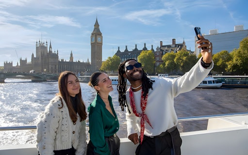 Group enjoying a selfie on a London sightseeing cruise with Big Ben in the background.