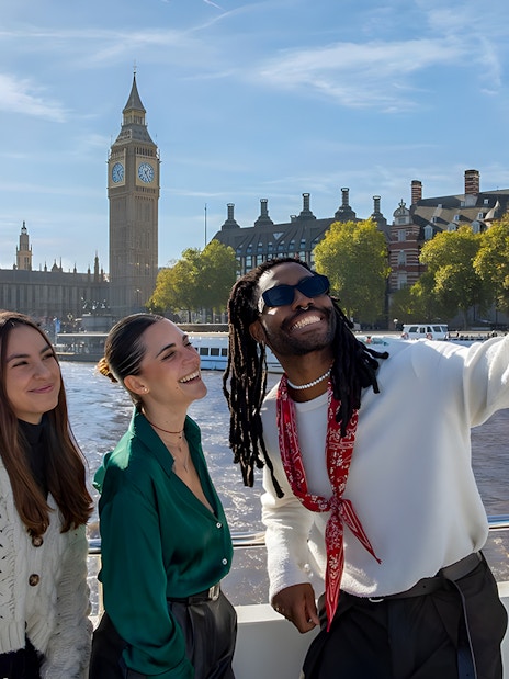 Group enjoying a selfie on a London sightseeing cruise with Big Ben in the background.