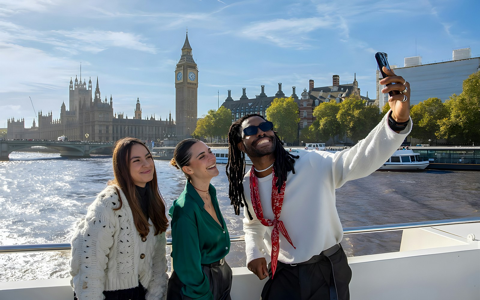 Group enjoying a selfie on a London sightseeing cruise with Big Ben in the background.