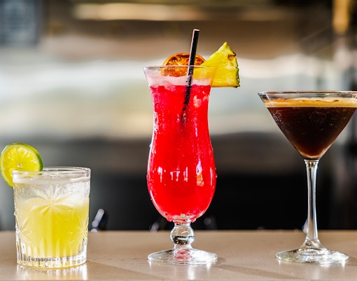 Cocktails on bar at Gold Coast buffet lunch, featuring lime, pineapple, and espresso drinks.