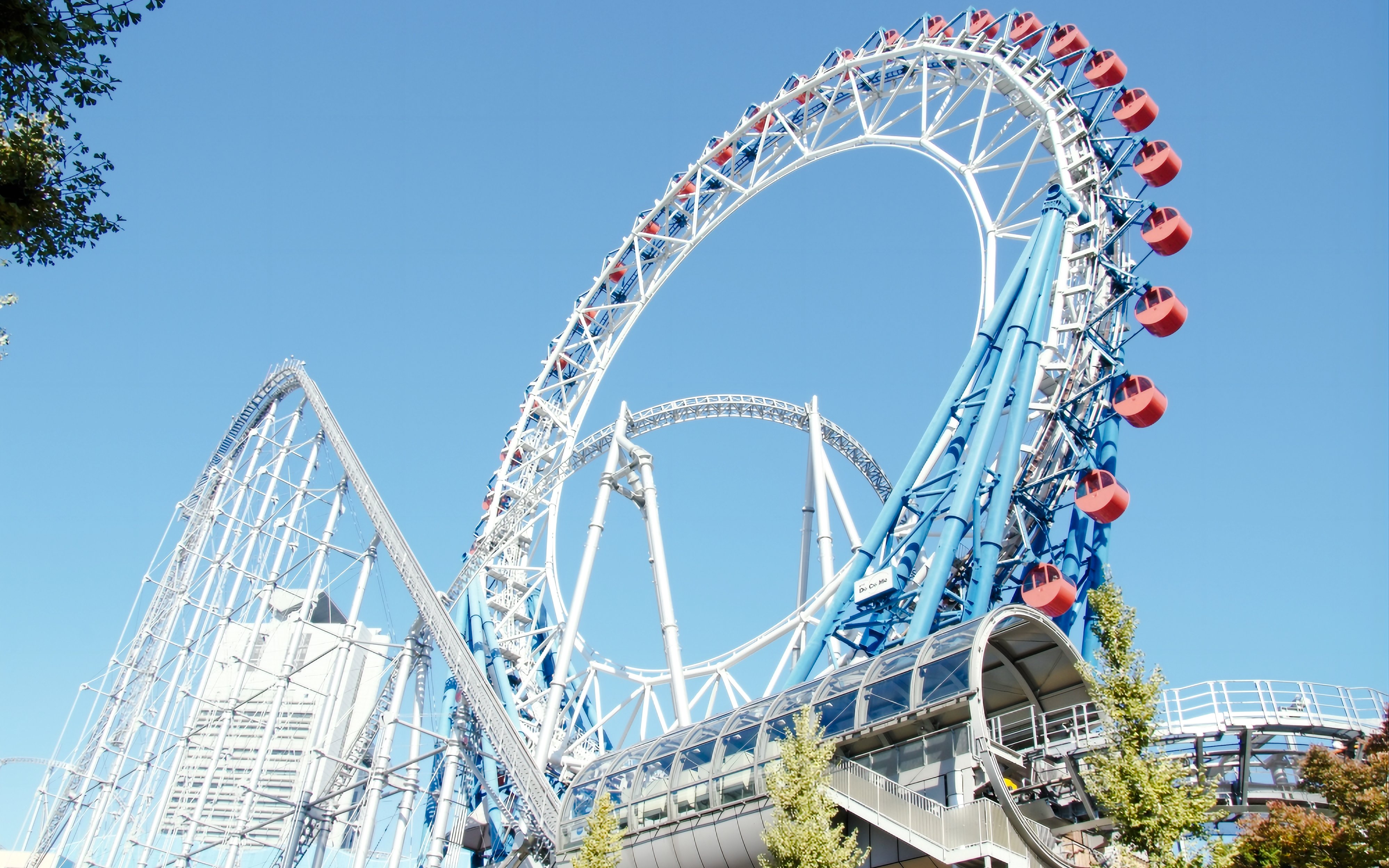 Roller coaster at Tokyo Dome City with blue sky backdrop.