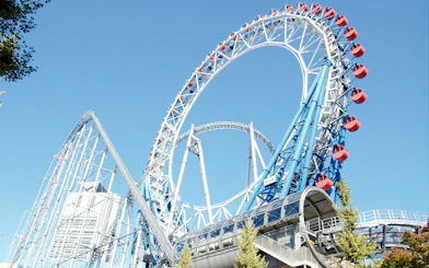 Roller coaster at Tokyo Dome City with blue sky backdrop.