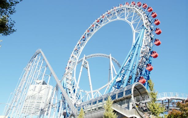 Roller coaster at Tokyo Dome City with blue sky backdrop.