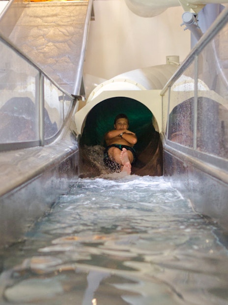 Person sliding down Saturn slide in Galaxy Zone at Therme Bucharest.
