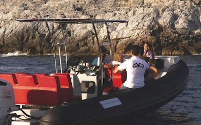 Boat with tourists near rocky coastline on La Spezia: Portovenere and 3 Islands trip.