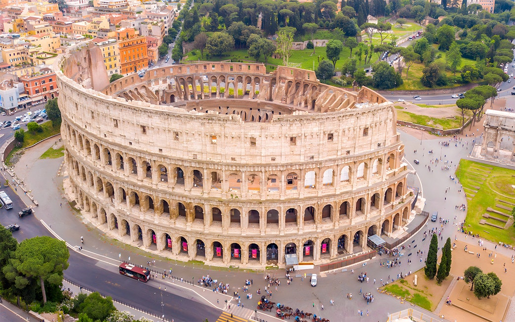Aerial view of the Colosseum in Rome with surrounding cityscape.