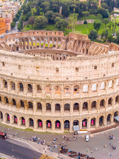 Aerial view of the Colosseum in Rome with surrounding cityscape.