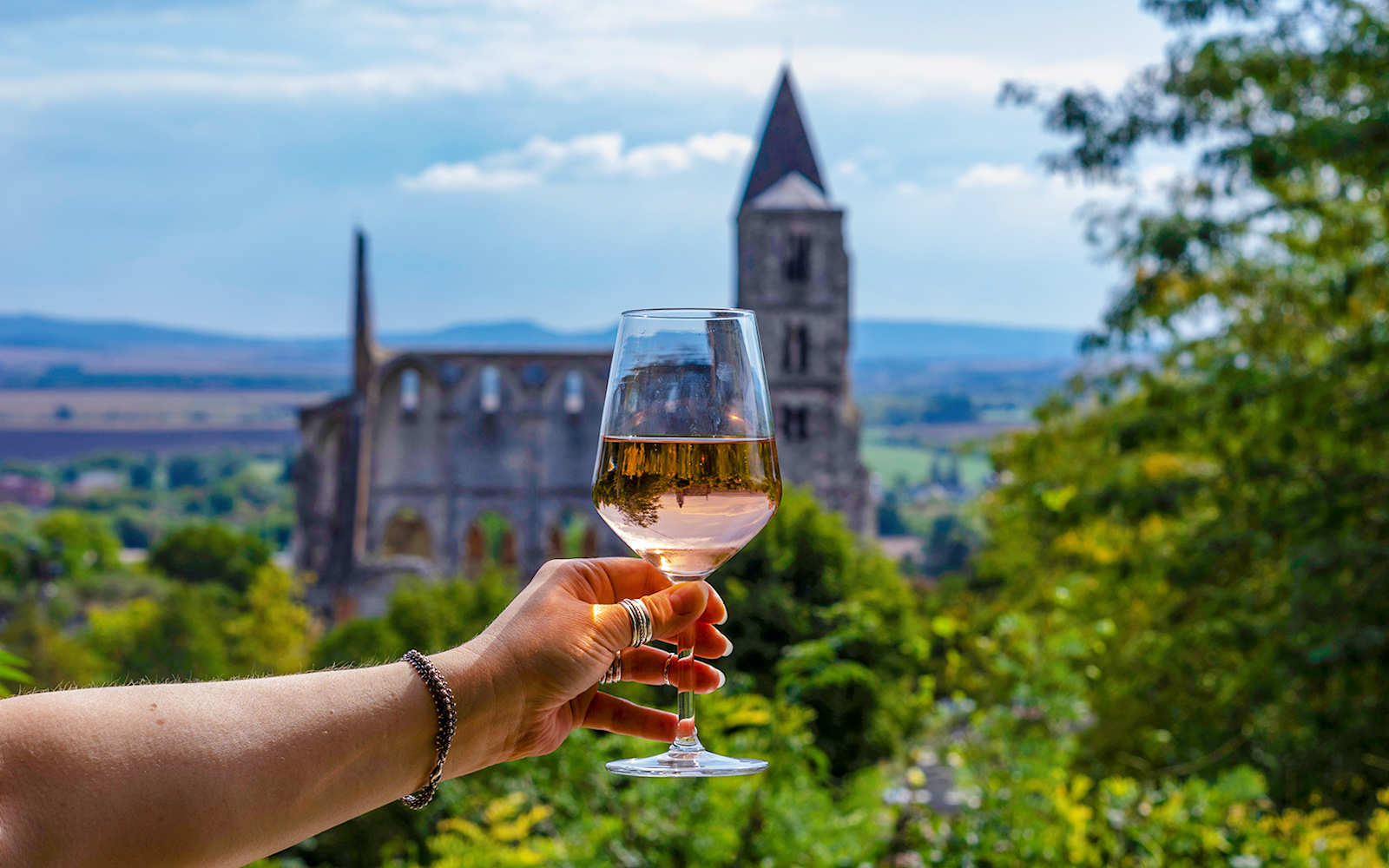 Guests enjoying wine with a view of Etyek Wine Region's historic church.