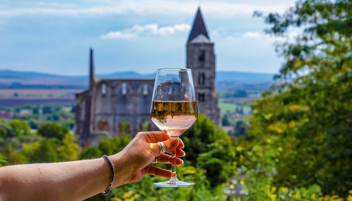 Guests enjoying wine with a view of Etyek Wine Region's historic church.