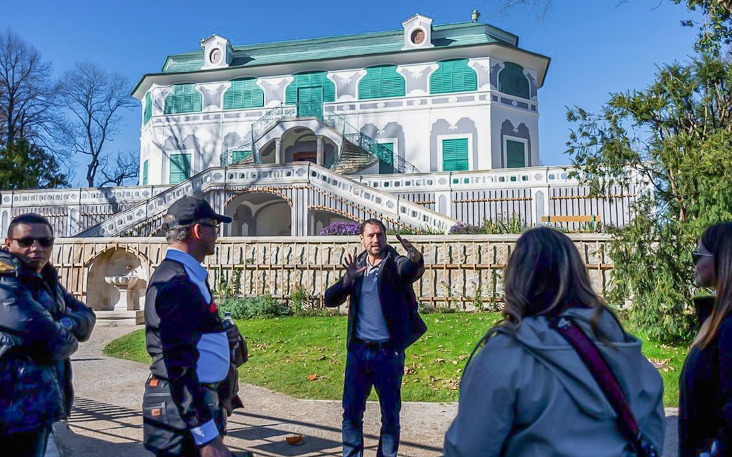 Tour guide explaining in front of a historic building in Cesky Krumlov.