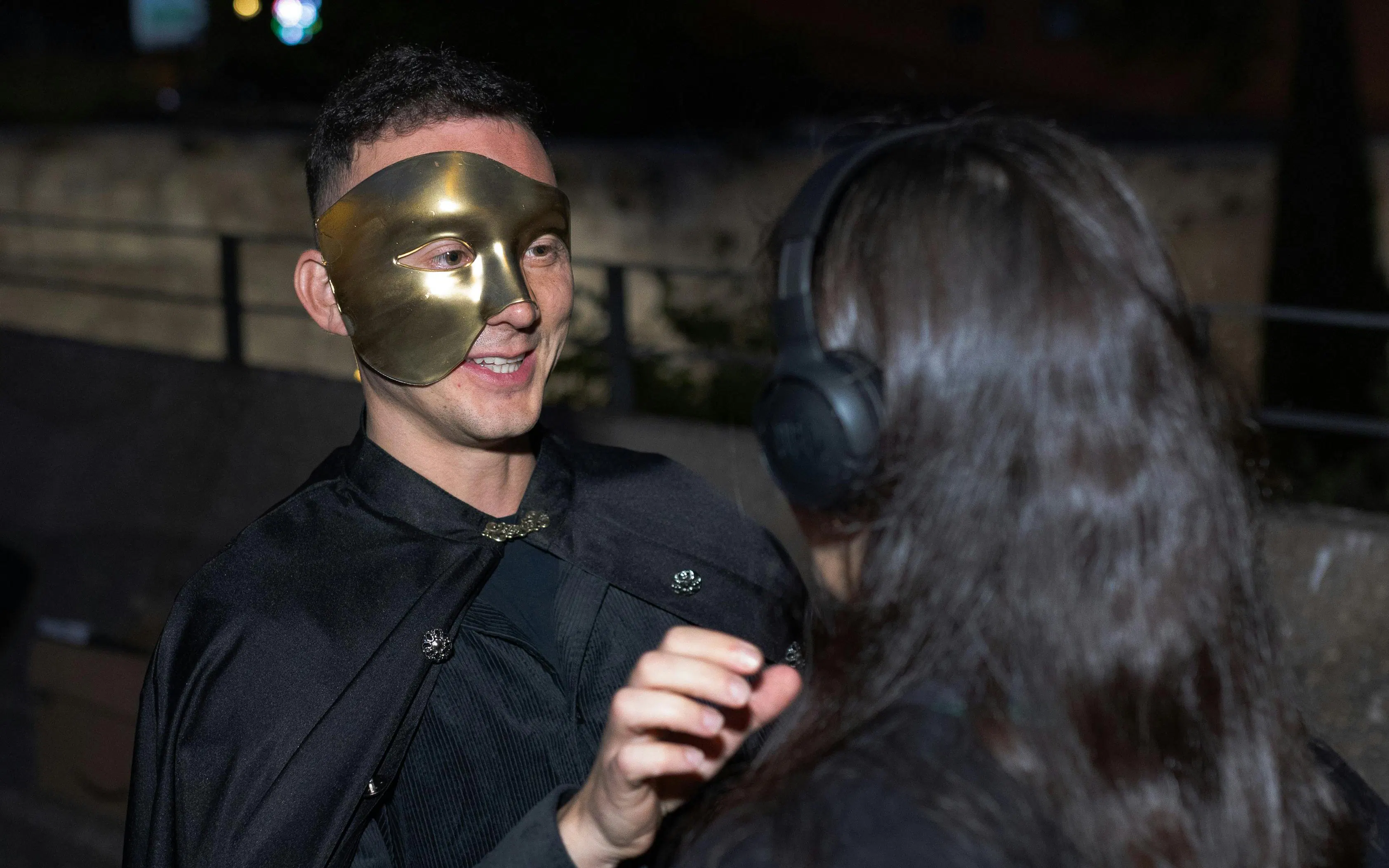 Tourist interacting with masked performer during theatrical tour in Madrid.