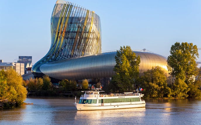 Cruise boat on Bordeaux river near La Cité du Vin museum.