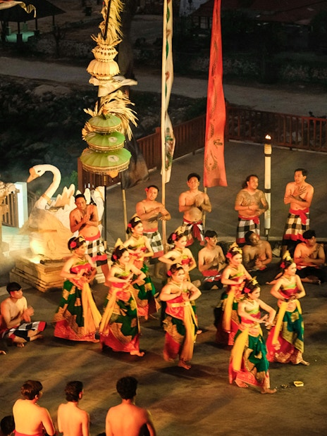 Kecak and Fire Dance performance at Melasti Beach, Bali, with dancers in traditional attire.