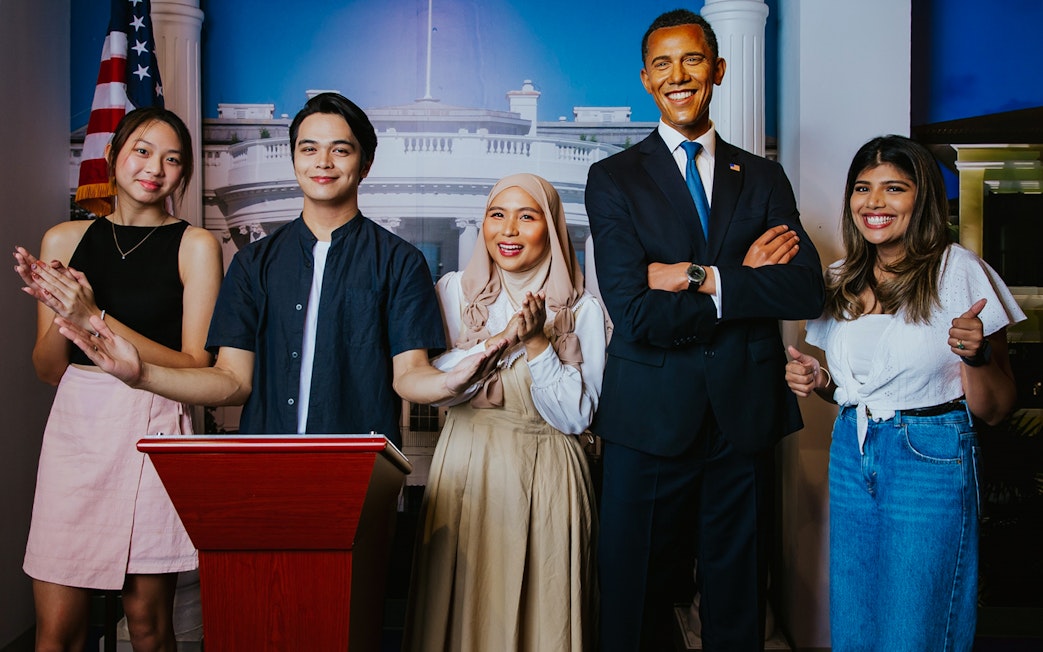 Visitors posing with Obama wax figure at Madame Tussauds Singapore.