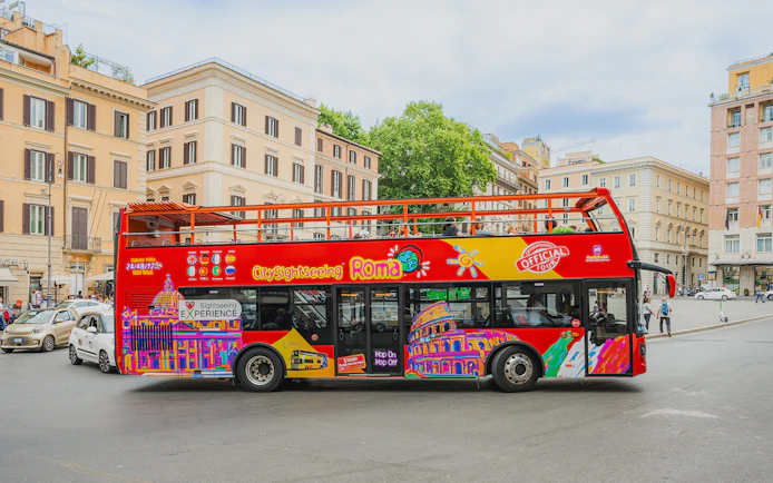 City Sightseeing bus in Rome with colorful graphics parked near historic buildings.
