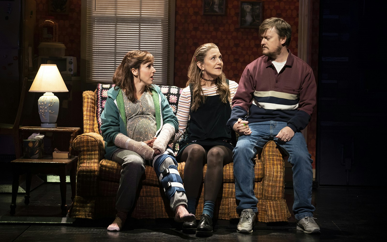 Three people sitting on a couch in a scene from the play "Kimberly Akimbo.