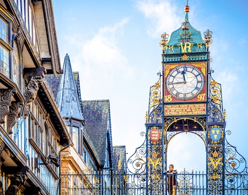 Woman standing on the bridge in front of Eastgate clock of Chester