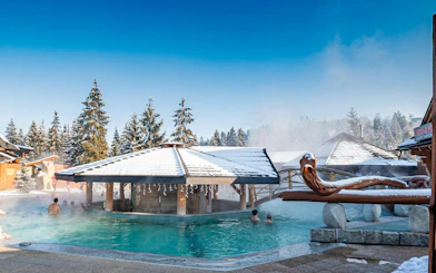 Gorący Potok Thermal Baths with snow-covered roofs and people enjoying the warm water in Poronin.